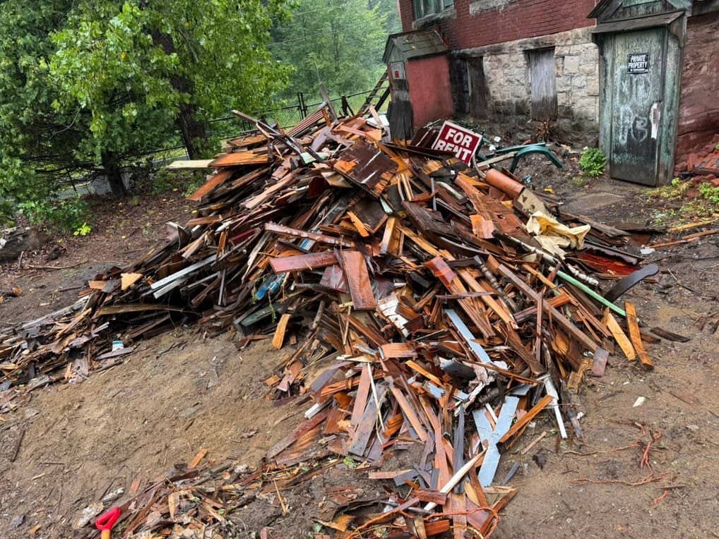 Large pile of torn-out wood boards and construction debris waiting for haul-away