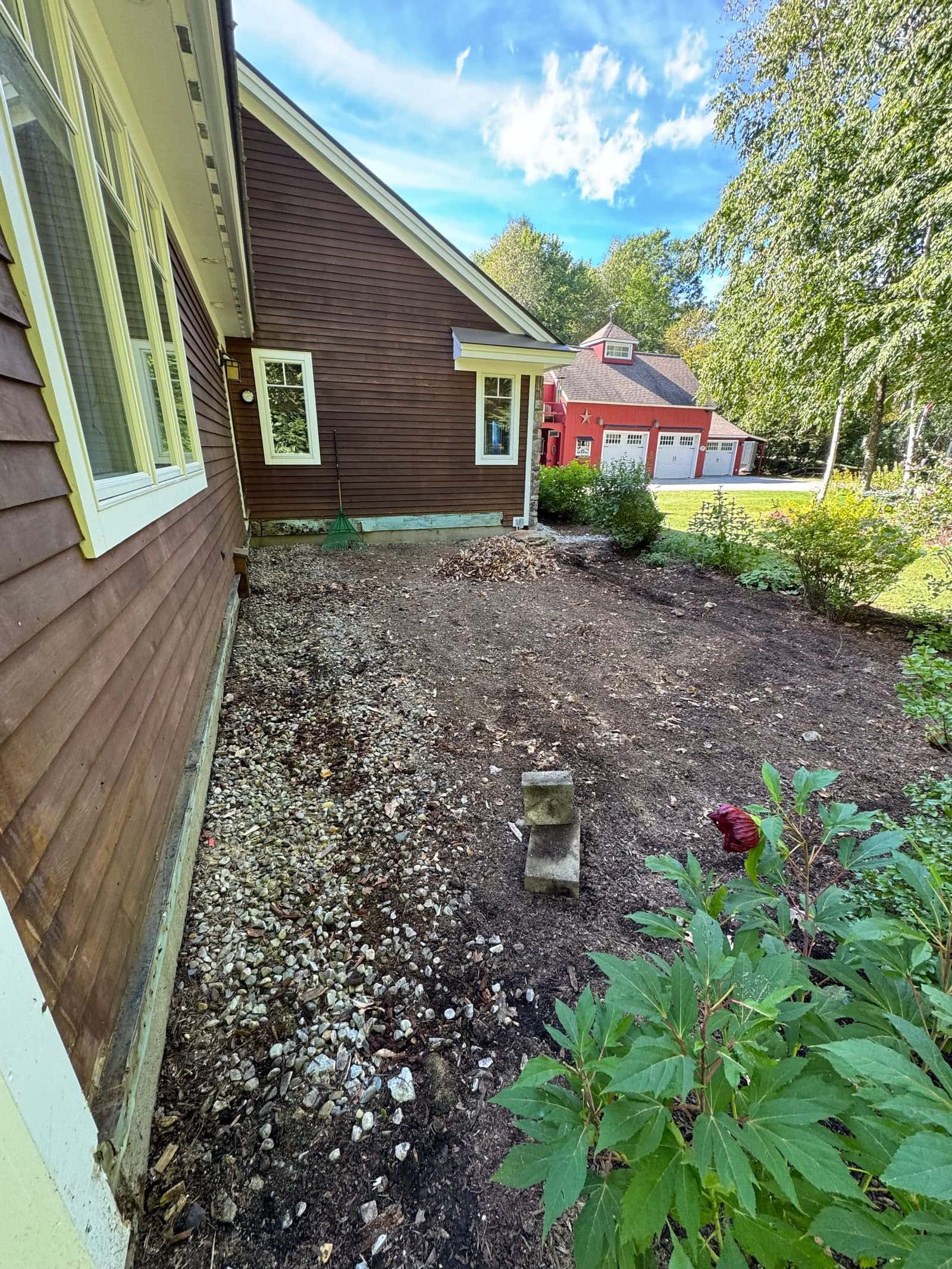 Same house after the deck was removed: bare ground and gravel beside the house