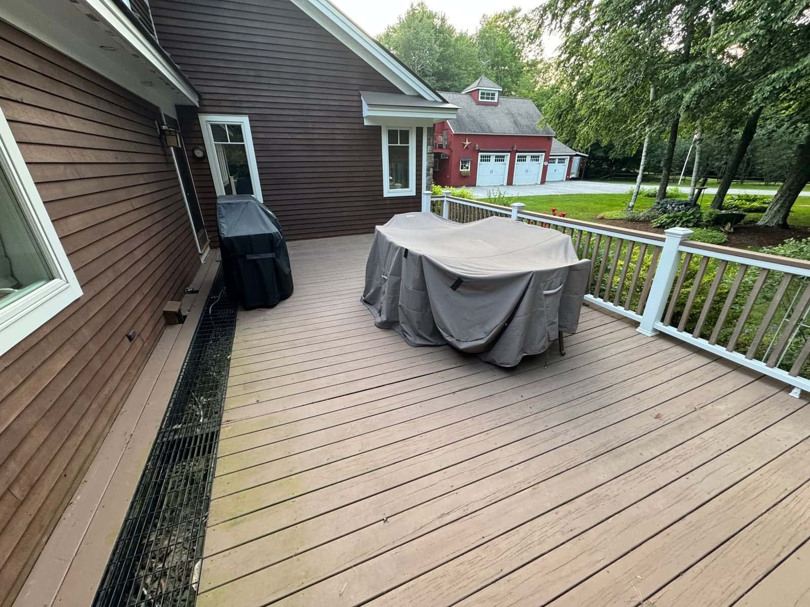 Customer photo of the old wood deck with patio table and grill before removal